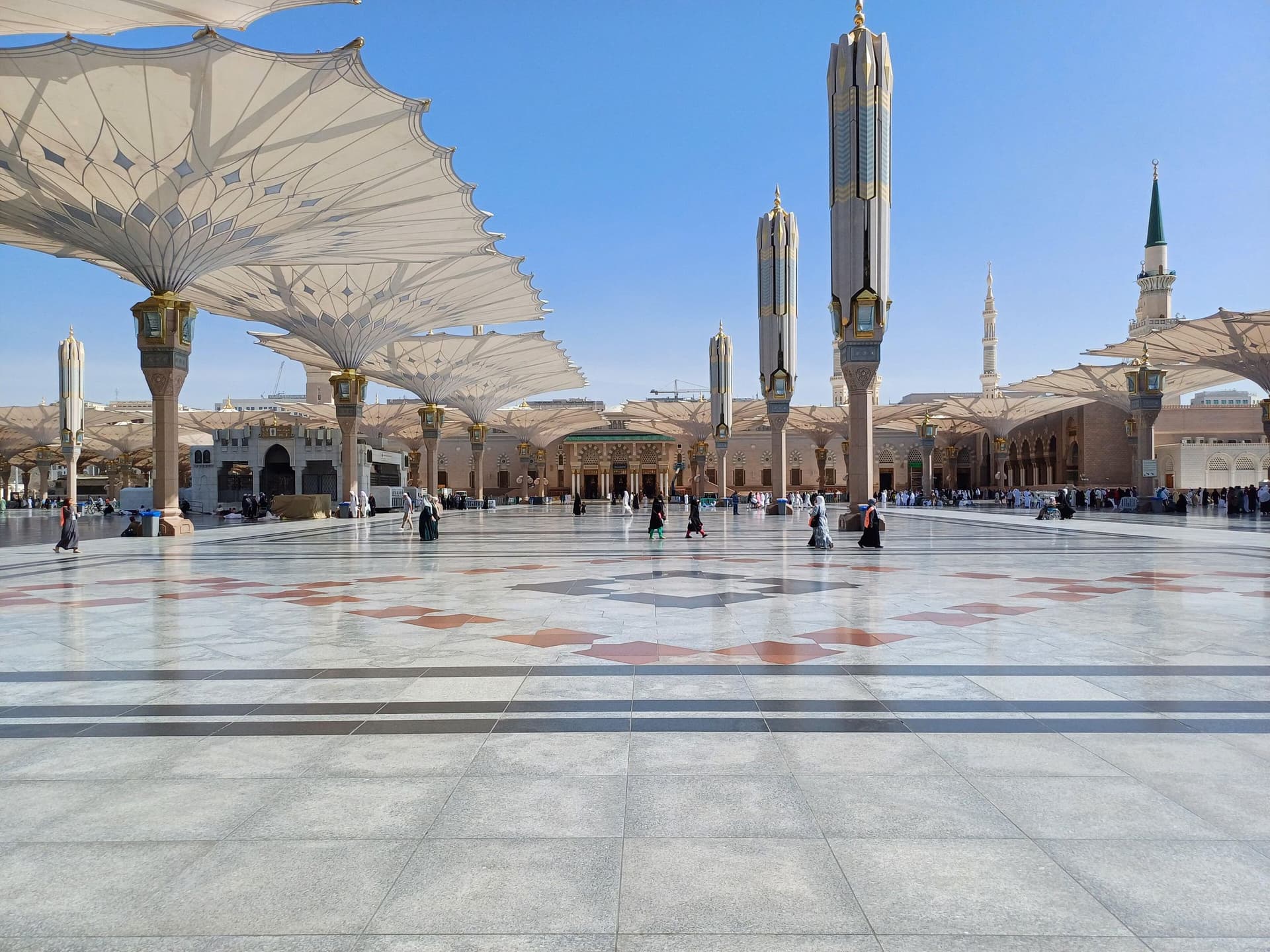 Mescid-i Nebevi avlusundaki dev şemsiyeler ve mavi gökyüzüne yükselen minareler