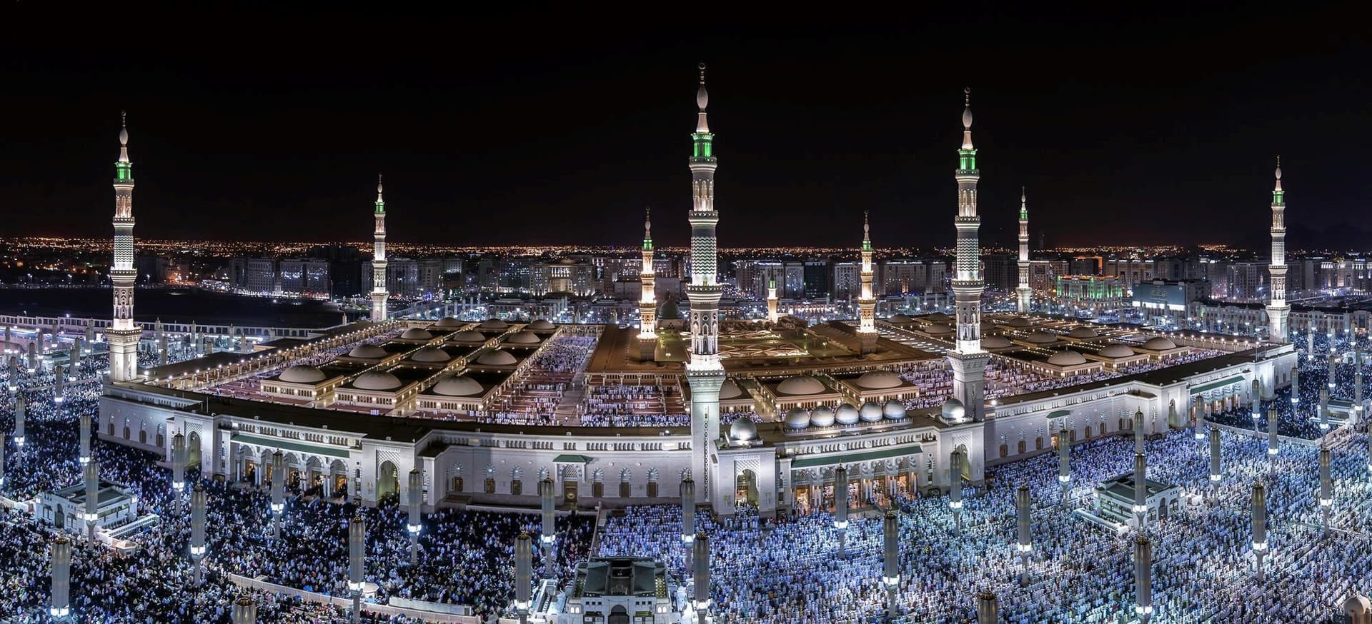 Gece ışıklarıyla aydınlanan Mescid-i Nebevi ve minareleri, yüksekten görünüm